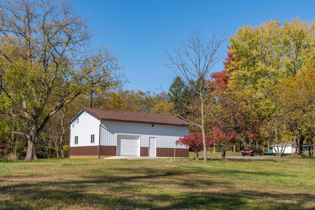 view of yard featuring a garage and an outbuilding