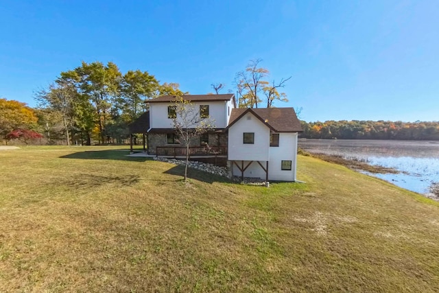 rear view of house featuring a lawn and a water view