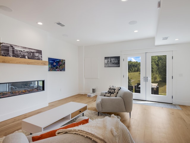 living room featuring french doors and light wood-type flooring