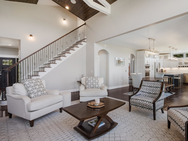 living room with light wood-type flooring and high vaulted ceiling