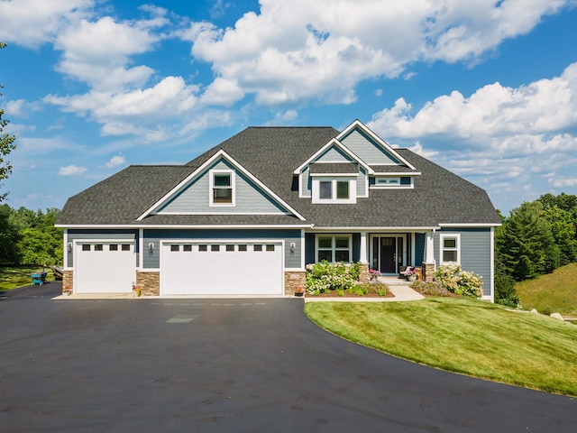 craftsman inspired home with a garage and a front lawn