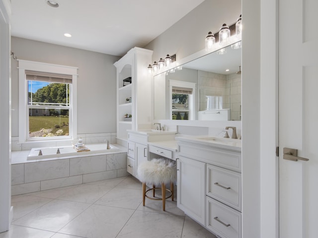 bathroom with vanity and tiled tub