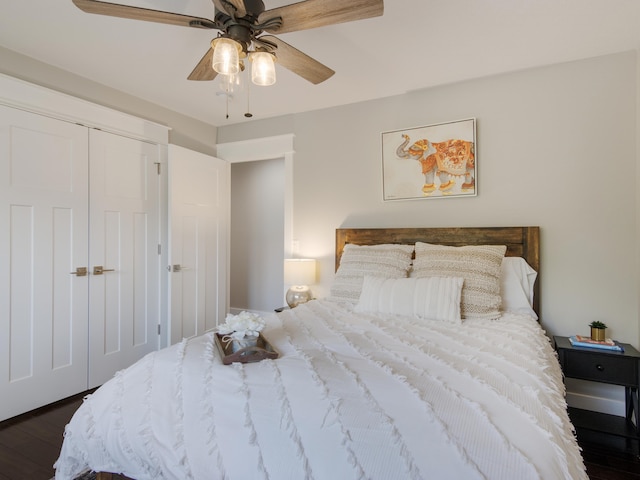 bedroom with a closet, dark hardwood / wood-style floors, and ceiling fan