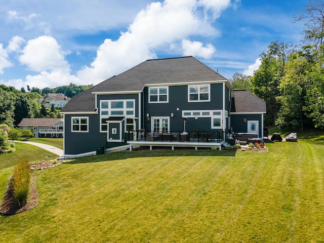 rear view of property featuring a deck and a lawn