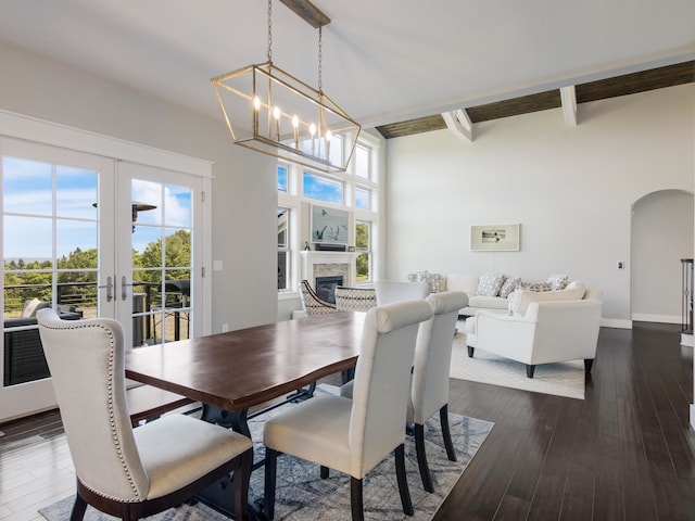 dining space featuring high vaulted ceiling, french doors, a notable chandelier, beam ceiling, and dark hardwood / wood-style flooring