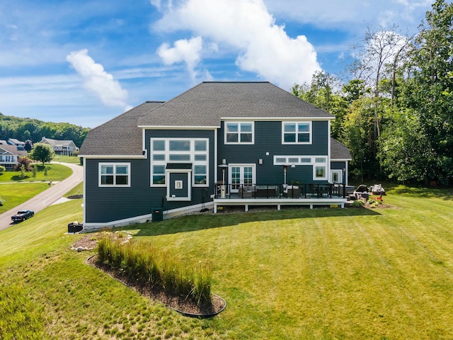 back of house featuring a deck and a yard