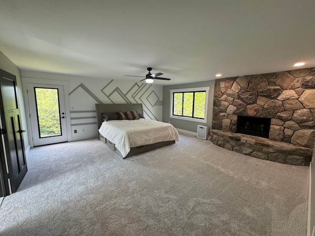 unfurnished bedroom with a fireplace, ceiling fan, light colored carpet, and access to outside