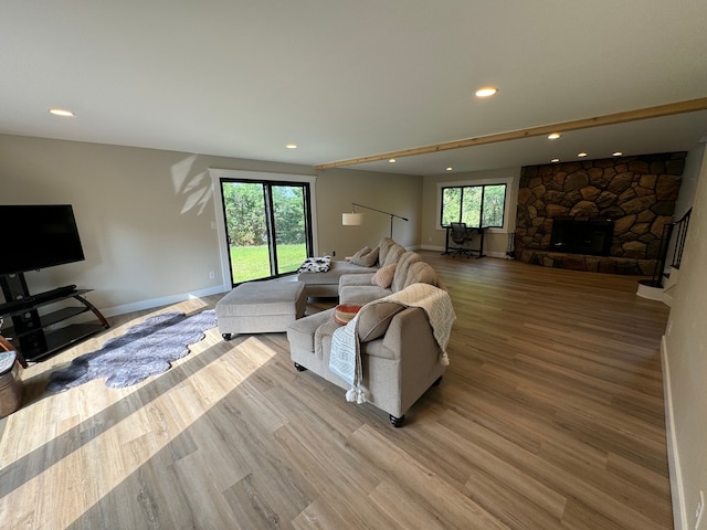 living room featuring a fireplace, a wealth of natural light, and light hardwood / wood-style floors