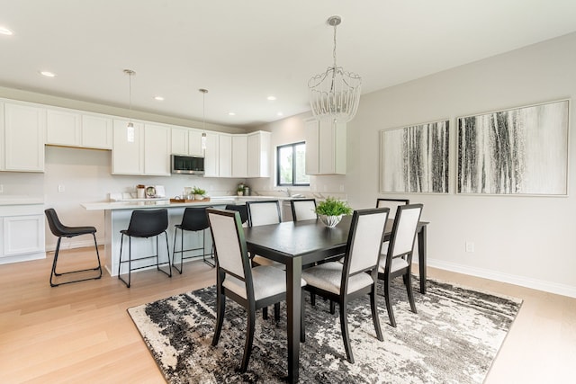 dining room with a chandelier and light wood-type flooring