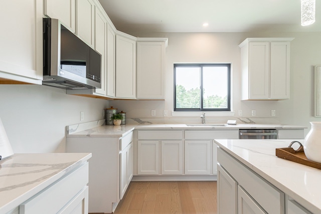 kitchen with white cabinets, light wood-type flooring, sink, and appliances with stainless steel finishes