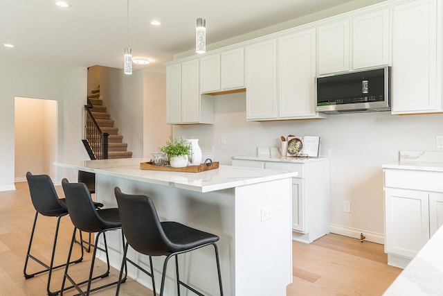 kitchen featuring light hardwood / wood-style flooring, white cabinetry, and a kitchen island