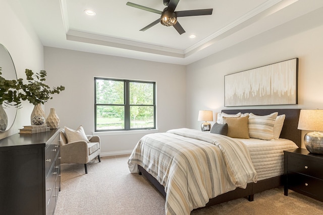 carpeted bedroom with ceiling fan, ornamental molding, and a tray ceiling