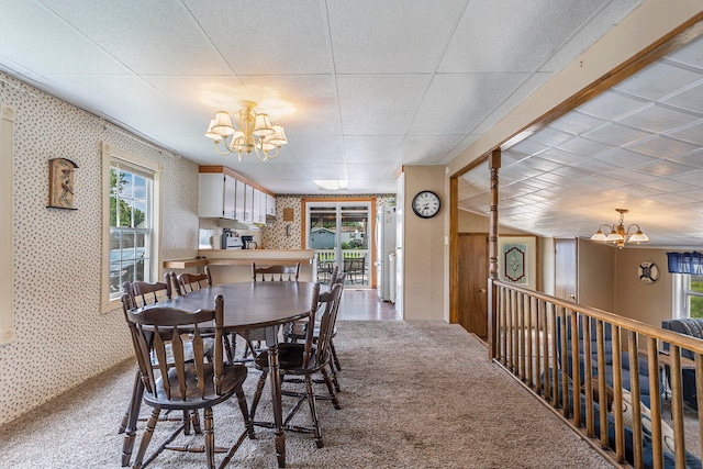 carpeted dining space with an inviting chandelier