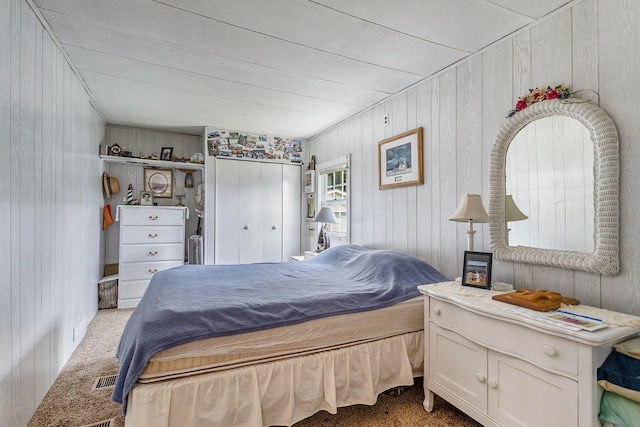 bedroom featuring wooden walls and carpet