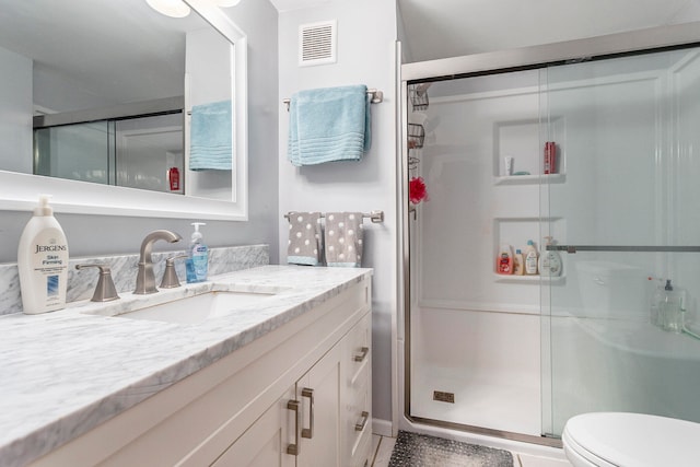 bathroom with vanity, toilet, and an enclosed shower