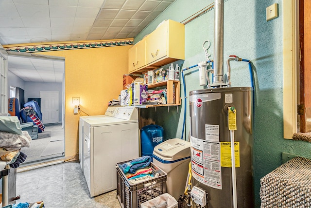 laundry area with water heater, cabinets, and washer / dryer