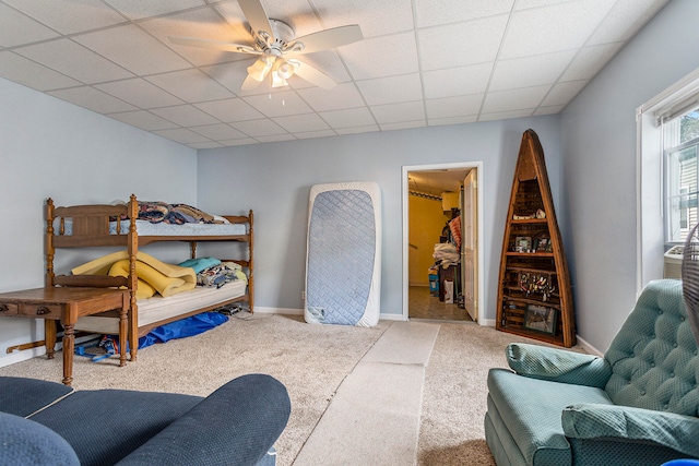 bedroom featuring carpet, a drop ceiling, and ceiling fan