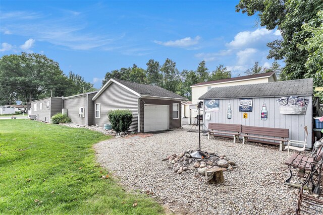 486 Maple Ln, Coldwater, MI 49036 - view of side of property featuring an outdoor structure, roof with shingles, a lawn, and an attached garage