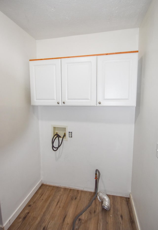 washroom with dark hardwood / wood-style flooring, cabinets, and washer hookup