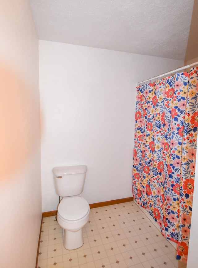 bathroom with toilet and a textured ceiling