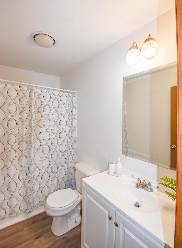 bathroom featuring vanity, wood-type flooring, and toilet