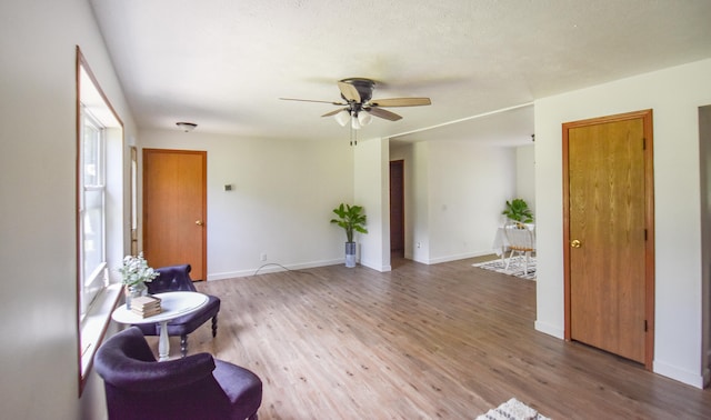 sitting room with hardwood / wood-style floors and ceiling fan