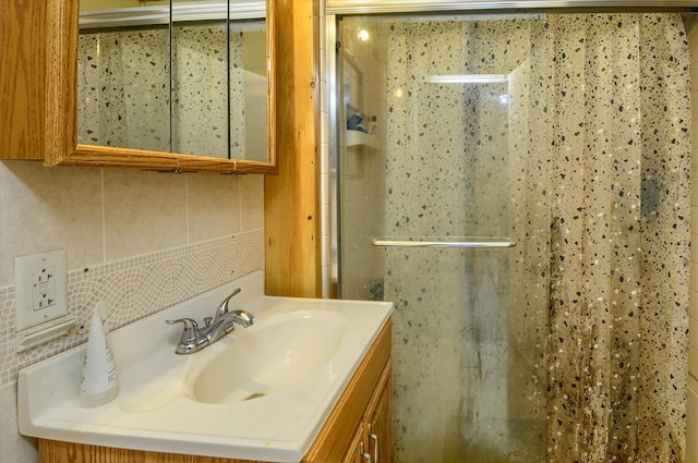 bathroom featuring tasteful backsplash, vanity, and walk in shower