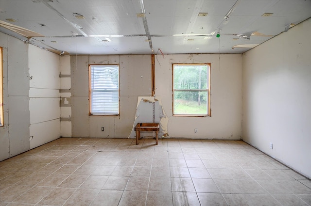 spare room featuring light tile patterned flooring and plenty of natural light