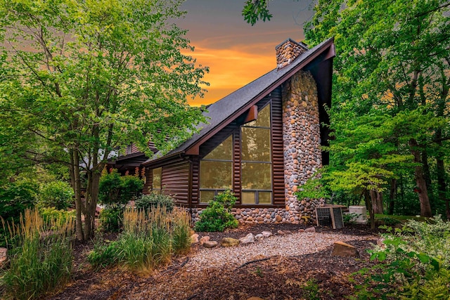 property exterior at dusk featuring central air condition unit