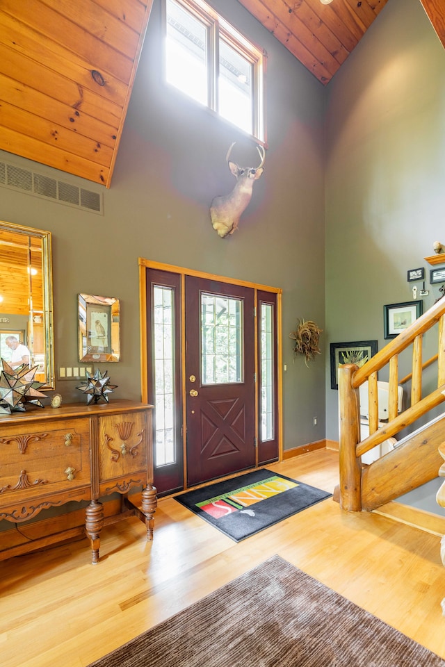 entrance foyer with light hardwood / wood-style floors, high vaulted ceiling, and wooden ceiling