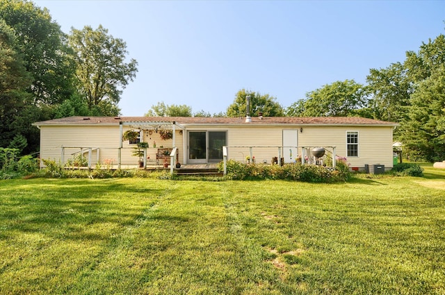 back of house with a pergola, a deck, cooling unit, and a lawn