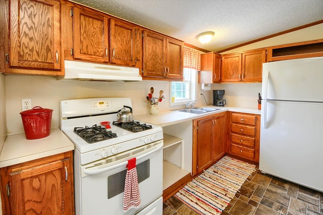 kitchen with a textured ceiling, white appliances, vaulted ceiling, and sink