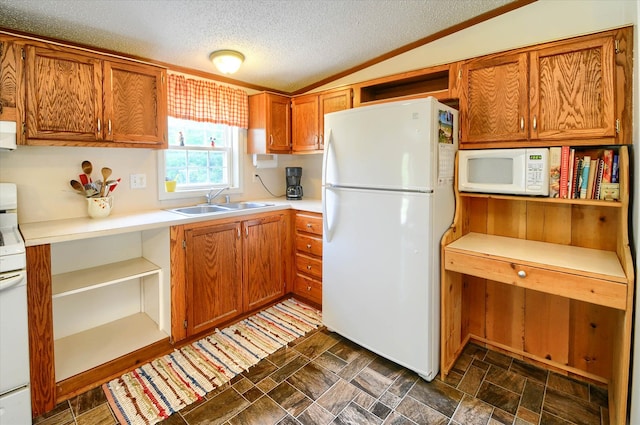 kitchen featuring sink, white appliances, a textured ceiling, and vaulted ceiling