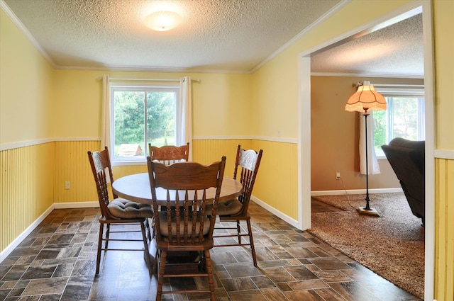 dining area with ornamental molding and a textured ceiling