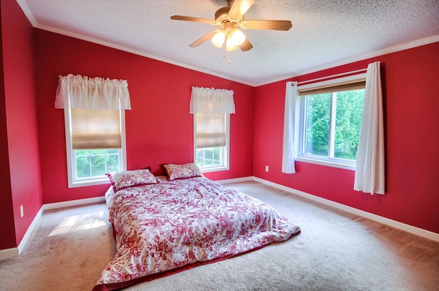 carpeted bedroom featuring a textured ceiling, multiple windows, crown molding, and ceiling fan