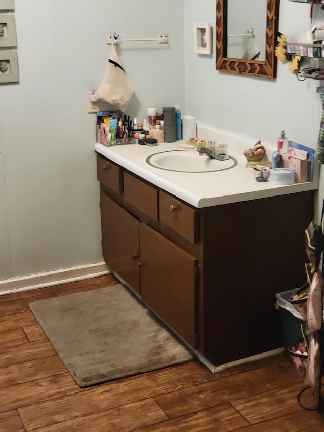 437 Ada Ave, Muskegon, MI 49442 - bathroom featuring vanity, tankless water heater, and wood finished floors