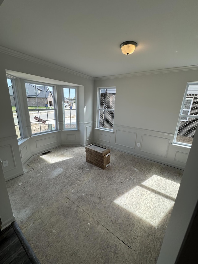 1476 Weeping Willow Ct, Ypsilanti, MI 48198 - empty room featuring a decorative wall, crown molding, and a wainscoted wall