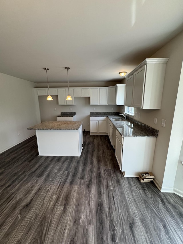 1476 Weeping Willow Ct, Ypsilanti, MI 48198 - kitchen with dark wood-style flooring, a kitchen island, pendant lighting, baseboards, and dark stone countertops