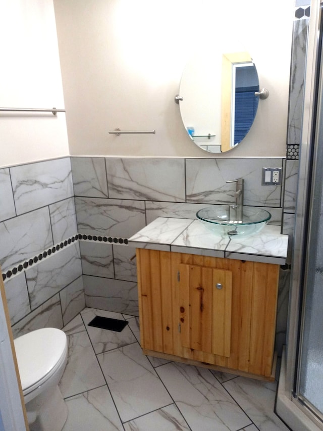 bathroom featuring vanity, toilet, and tile walls