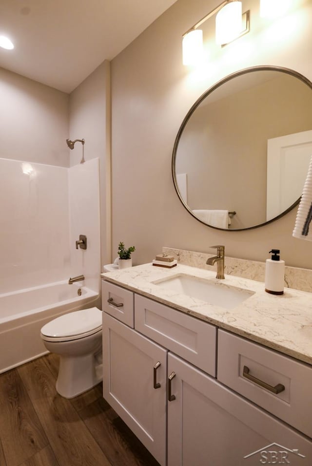 full bathroom with vanity, toilet, washtub / shower combination, and hardwood / wood-style flooring