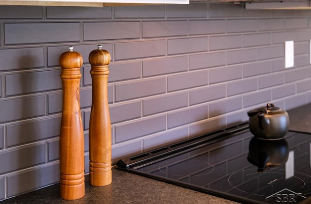 details featuring cooktop, gray cabinets, and backsplash