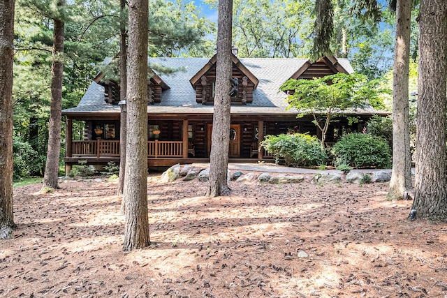 11245 Guyn Dr, Brighton, MI 48114 - cabin featuring roof with shingles, log exterior, and covered porch
