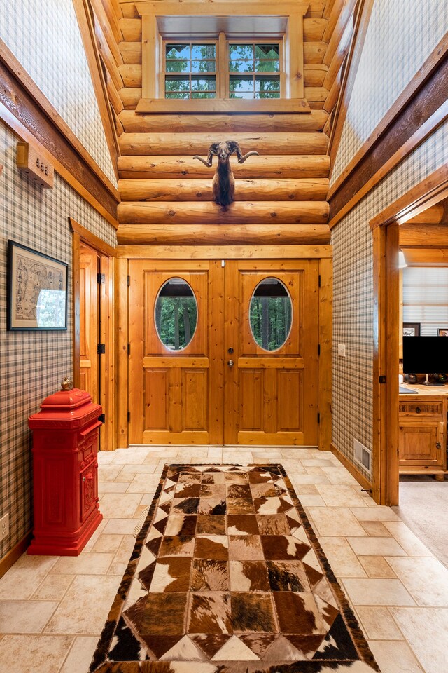 11245 Guyn Dr, Brighton, MI 48114 - foyer featuring a towering ceiling, stone tile floors, rustic walls, healthy amount of natural light, and baseboards