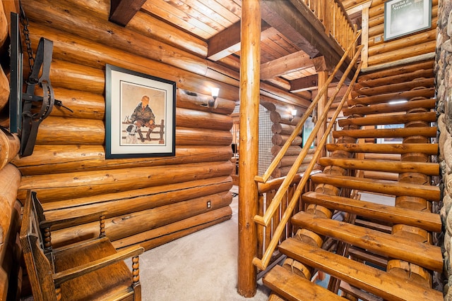 stairway with carpet flooring, rustic walls, beamed ceiling, and wooden ceiling