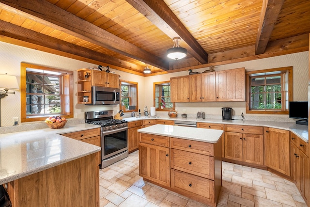 kitchen with beam ceiling, wooden ceiling, stainless steel appliances, light stone counters, and a kitchen island