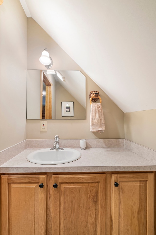 bathroom with vanity and lofted ceiling