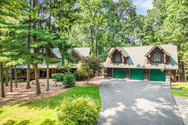 11245 Guyn Dr, Brighton, MI 48114 - view of front of property with a garage, driveway, log exterior, roof with shingles, and a front lawn