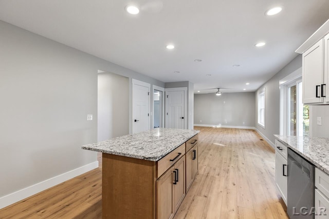 kitchen with dishwasher, ceiling fan, a kitchen island, light hardwood / wood-style floors, and white cabinetry