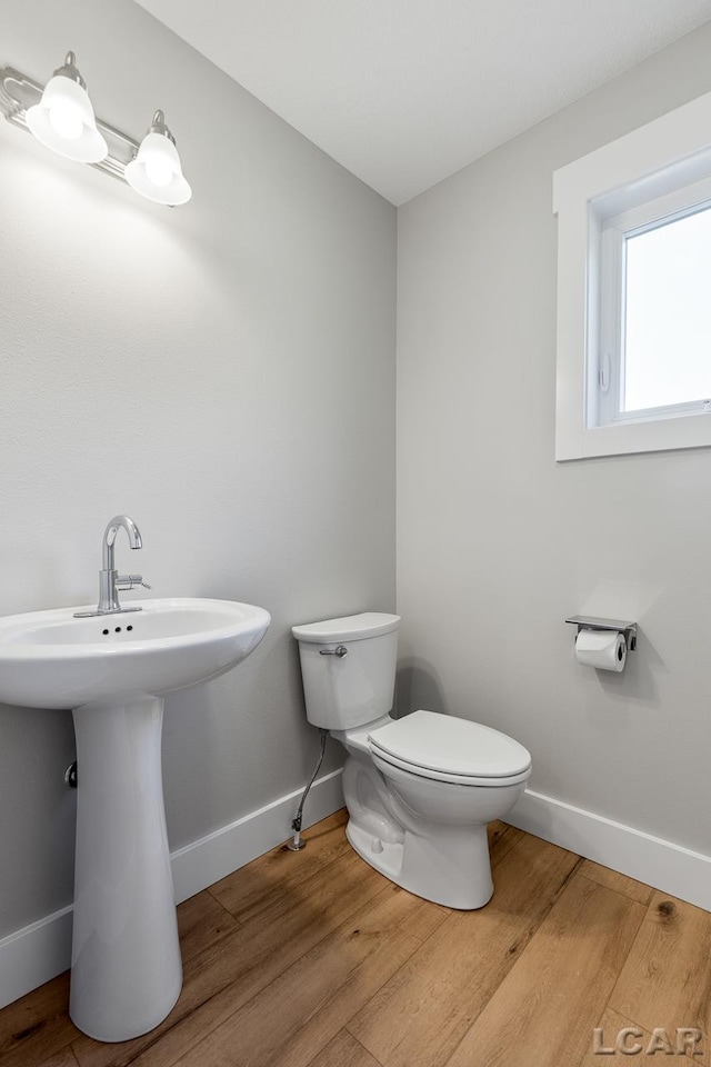 bathroom featuring toilet and wood-type flooring