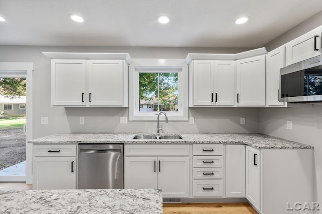 kitchen with white cabinetry, a healthy amount of sunlight, sink, and stainless steel appliances